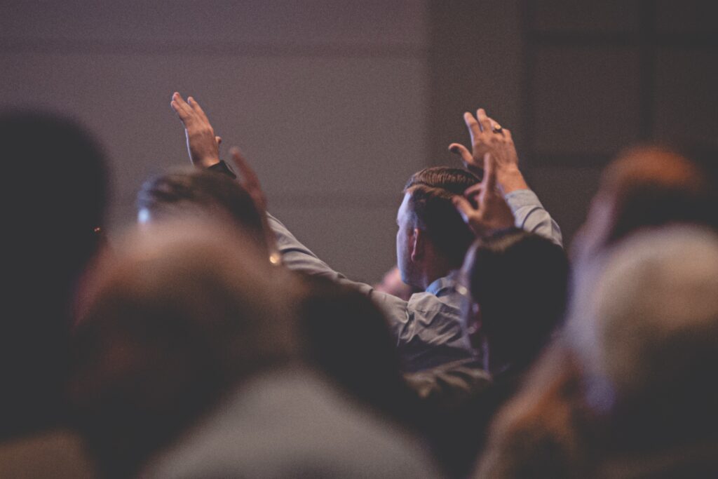 People raising hands at a conference